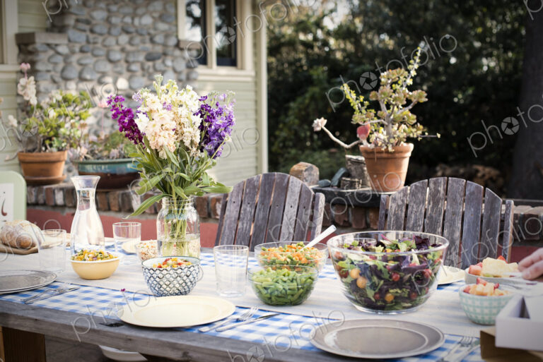 A table set for a meal outdoors in a garden.