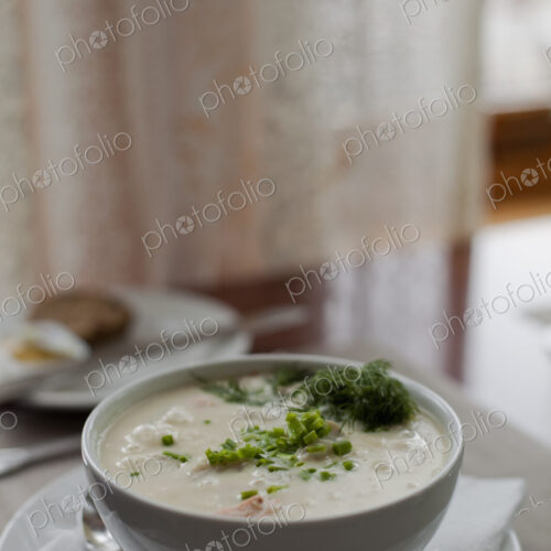 A table setting. A white china bowl of soup, with garnish. A table napkin. Wedding… A table setting. A white china bowl of soup, with garnish. A table napkin. Wedding…