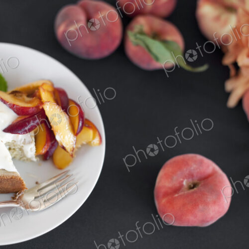 A table viewed from overhead. Organic fruit, peaches, and flowers. a plate with fresh…