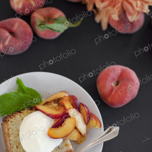 A table viewed from overhead. Organic fruit, peaches, and flowers. a plate with fresh…