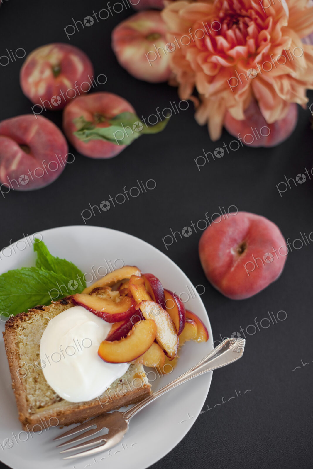 A table viewed from overhead. Organic fruit, peaches, and flowers. a plate with fresh…
