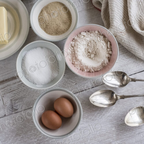 A table with ingredients for a baking project laid out, butter, sugar and flour, and…