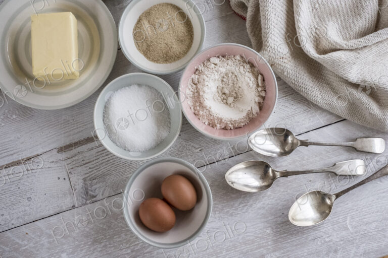 A table with ingredients for a baking project laid out, butter, sugar and flour, and…