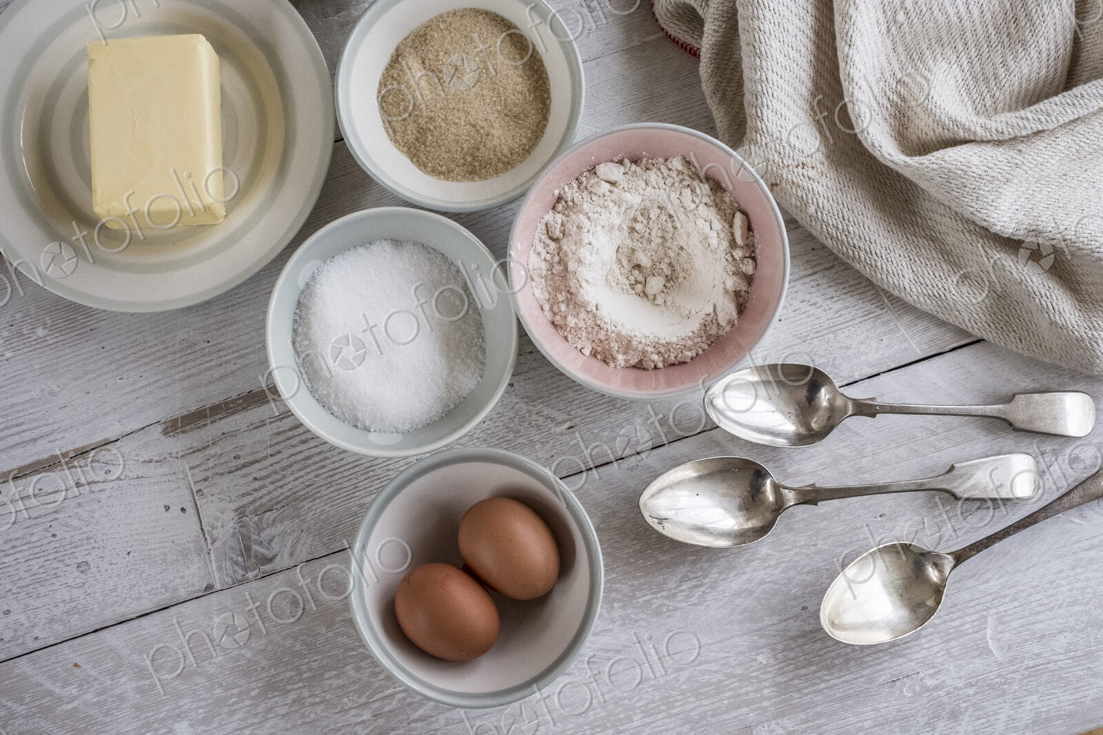 A table with ingredients for a baking project laid out, butter, sugar and flour, and…