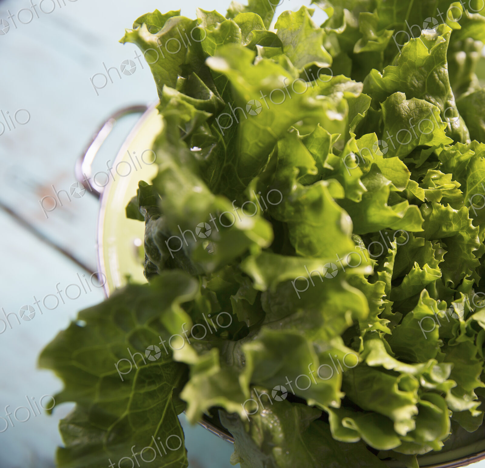 A tabletop with a bowl of salad leaves.