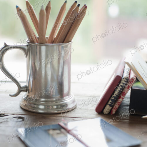 A tabletop with a silver tankard full of colouring crayons. Gift wrapped packages. A tabletop with a silver tankard full of colouring crayons. Gift wrapped packages.