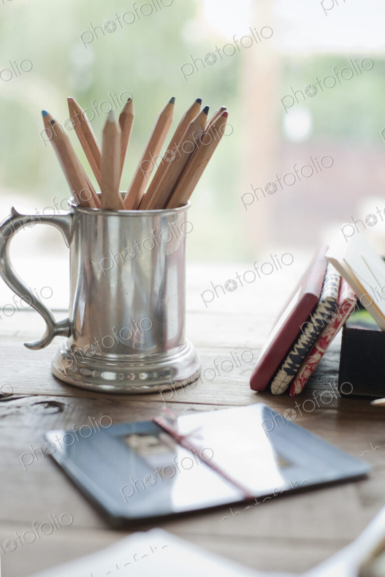 A tabletop with a silver tankard full of colouring crayons. Gift wrapped packages.