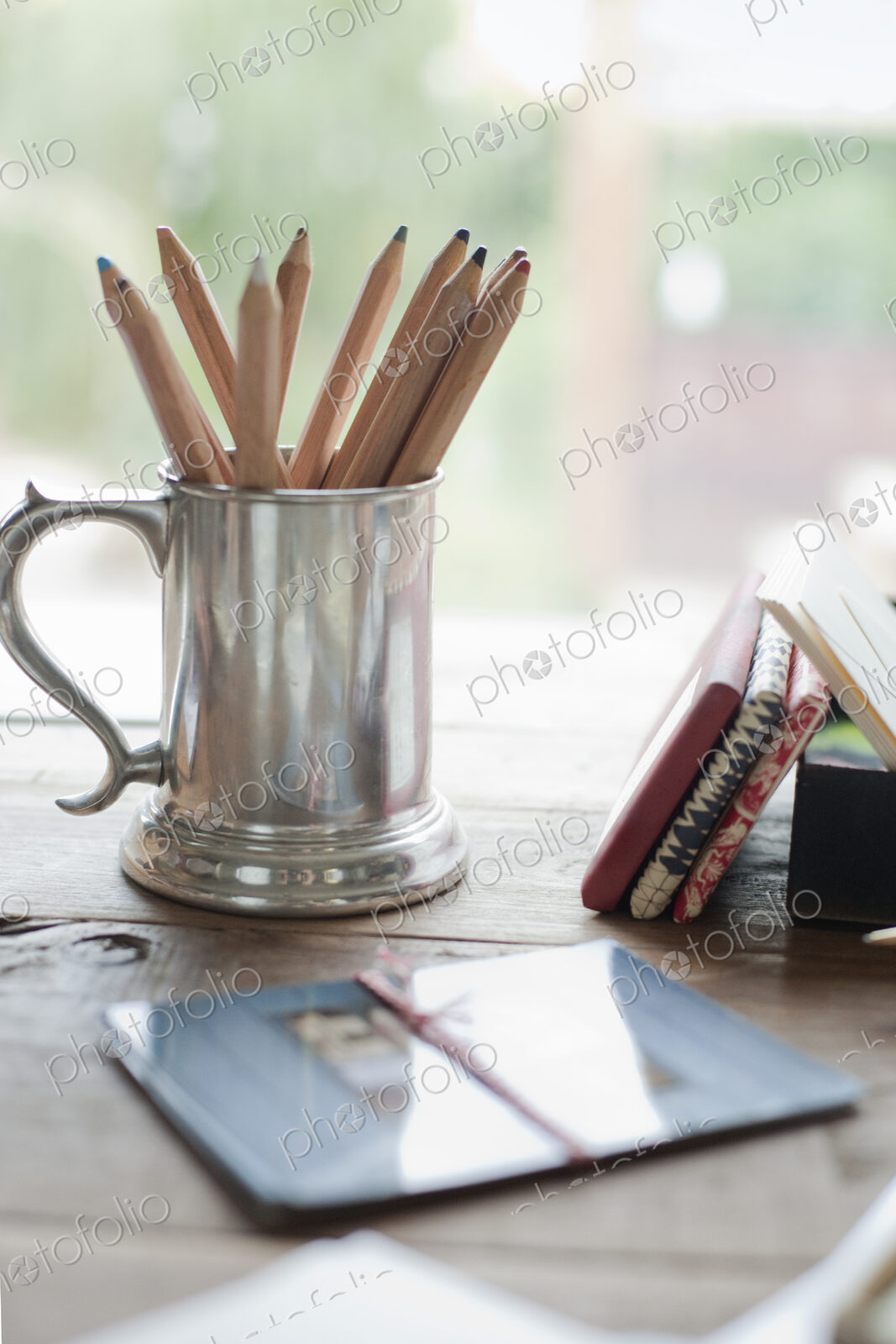 A tabletop with a silver tankard full of colouring crayons. Gift wrapped packages.