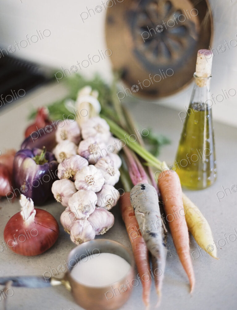 A tabletop. A group of fresh organic vegetables, carrots and onions, garlic and…