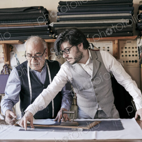 A tailor and a younger man, an assistant or apprentice working together, measuring… A tailor and a younger man, an assistant or apprentice working together, measuring…