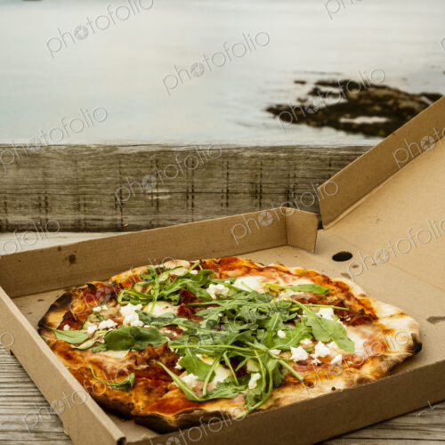 A takeaway pizza in a brown box.
