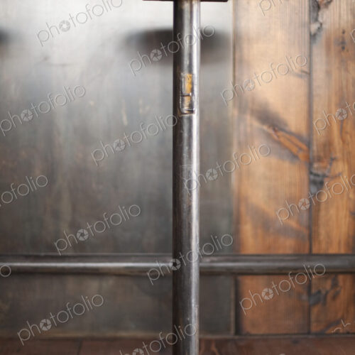 A tall bar stool by a wooden counter in a restaurant.