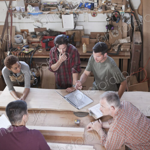 A team of multi-racial factory workers problem solving at a work station in a… A team of multi-racial factory workers problem solving at a work station in a…