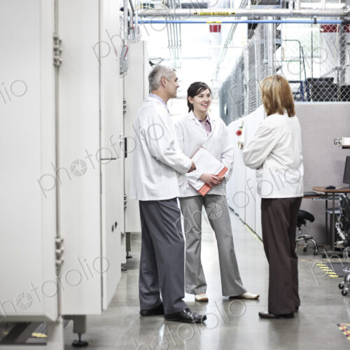 A team of technicians working over a problem in a technical research and development site. A team of technicians working over a problem in a technical research and development site.