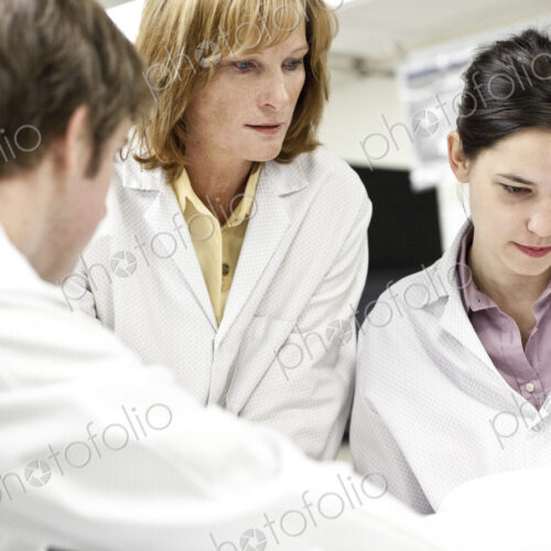 A team of technicians working over a problem in a technical research and development site.