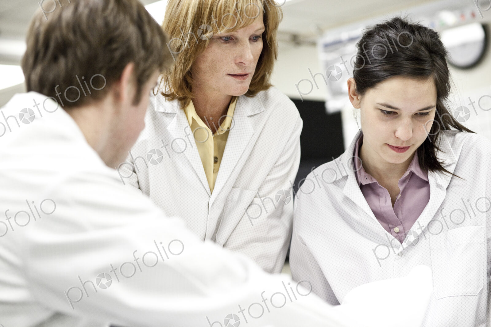 A team of technicians working over a problem in a technical research and development site.