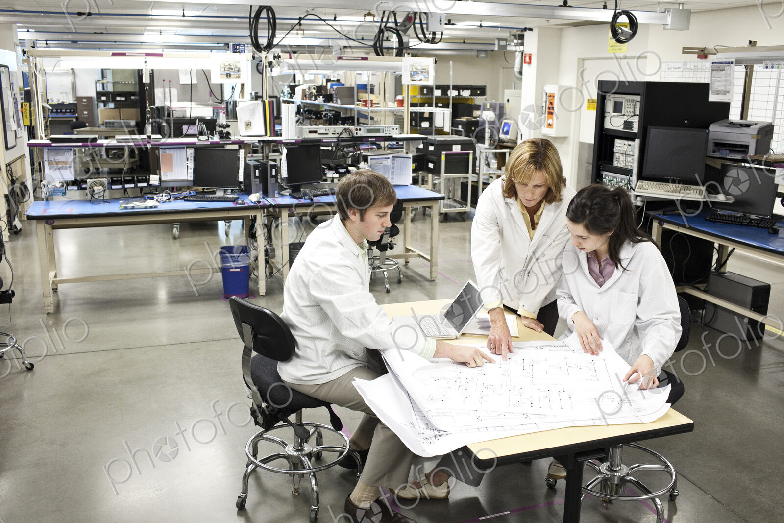 A team of technicians working over a problem in a technical research and development site.