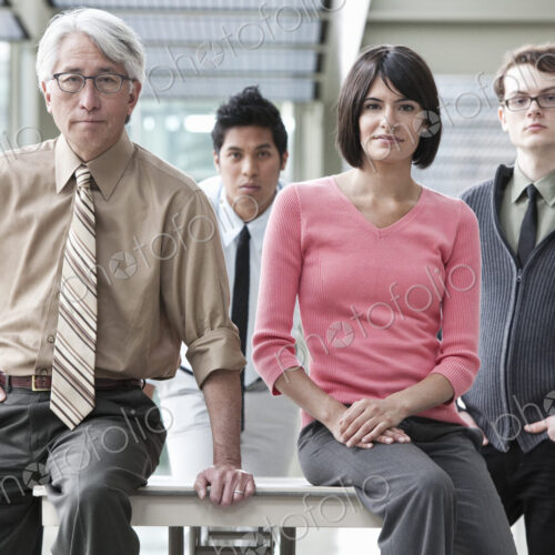 A team portrait of a mixed race group of business people with an Asian businessman in… A team portrait of a mixed race group of business people with an Asian businessman in…