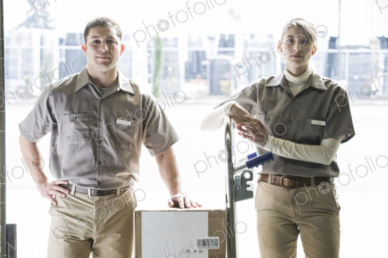 A team portrait of two caucasisn female and hispanic male uniformed warehouse workers .