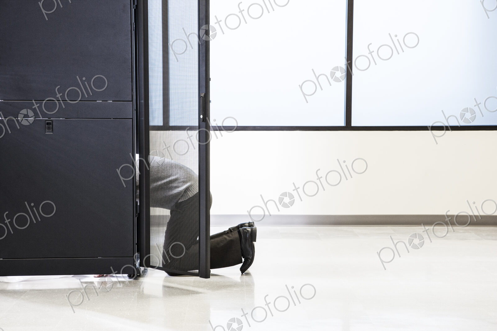 A technician working in the rack area of a computer server farm.