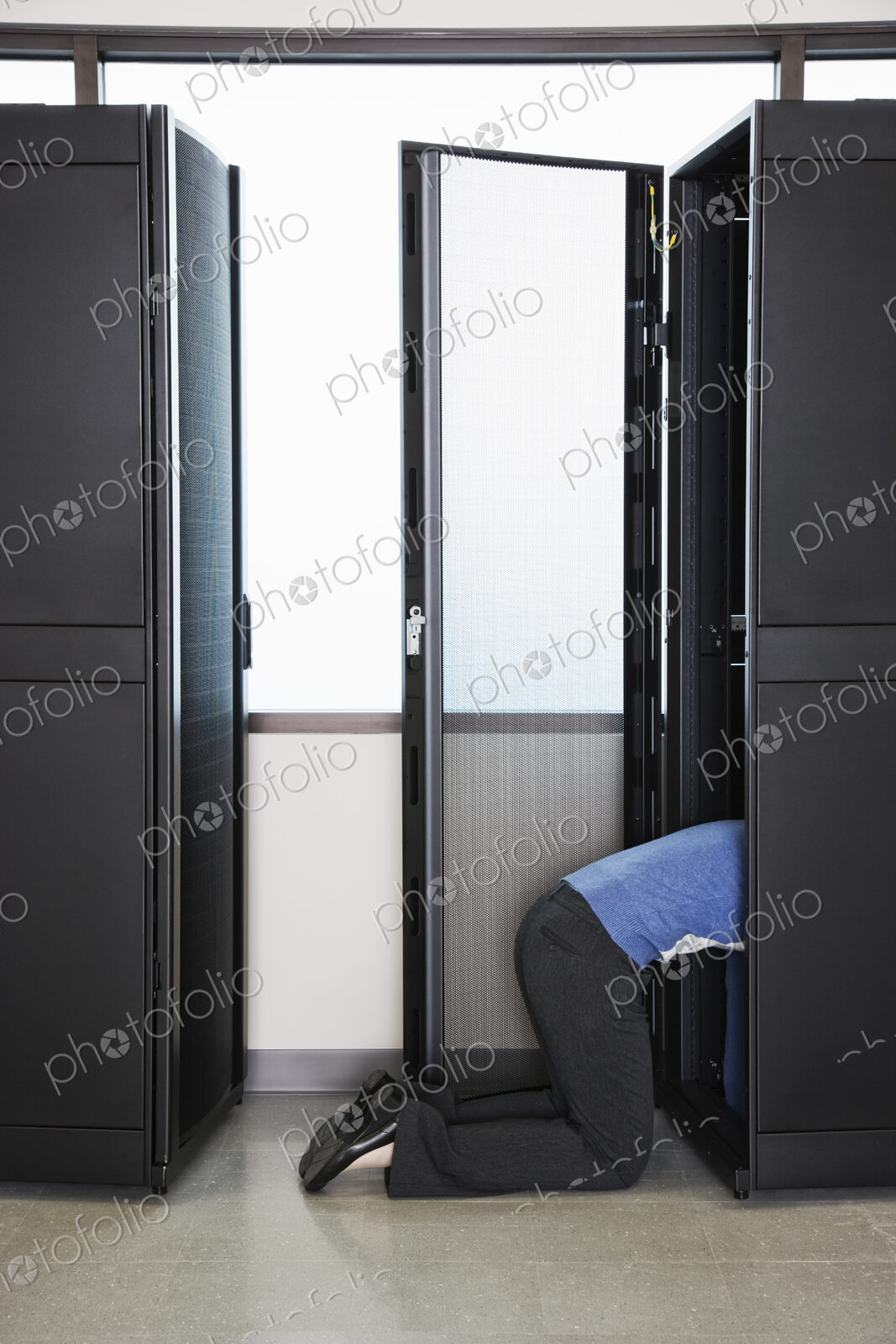 A technician working in the rack area of a computer server farm.
