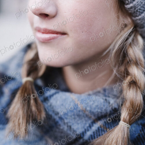 A teenage girl in a tartan plaid shawl and woolly hat outdoors in the winter. A teenage girl in a tartan plaid shawl and woolly hat outdoors in the winter.