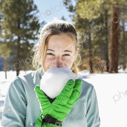 A teenage girl old girl holding and tasting a snowball