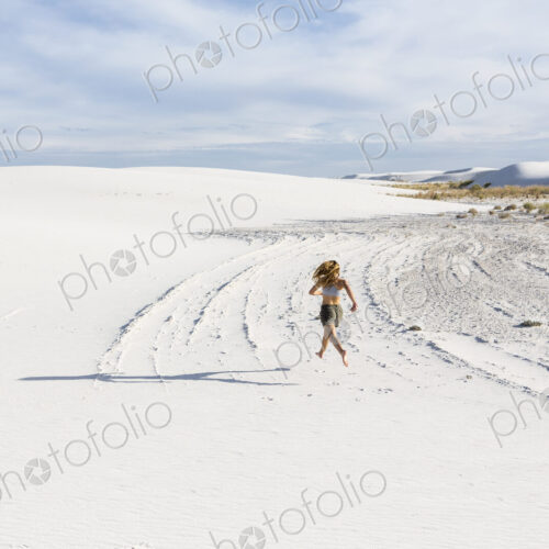 A teenage girl running in the sand, White Sands Nat'l Monument, NM A teenage girl running in the sand, White Sands Nat'l Monument, NM