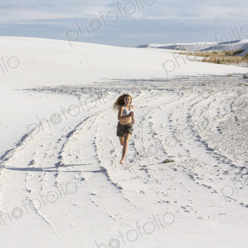 A teenage girl running in the sand, White Sands Nat'l Monument, NM A teenage girl running in the sand, White Sands Nat'l Monument, NM