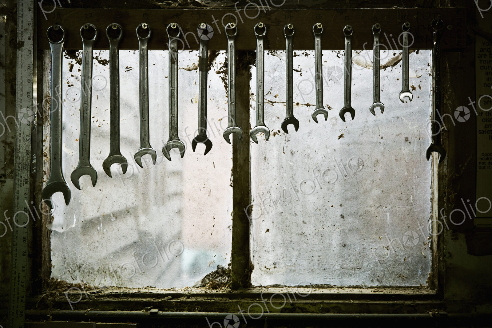 A tool rack with spanners of varying sizes hanging up in order.