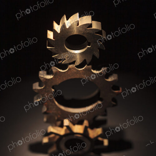 A toy model of a Businessman standing by three stacked cog wheels with different gearing.