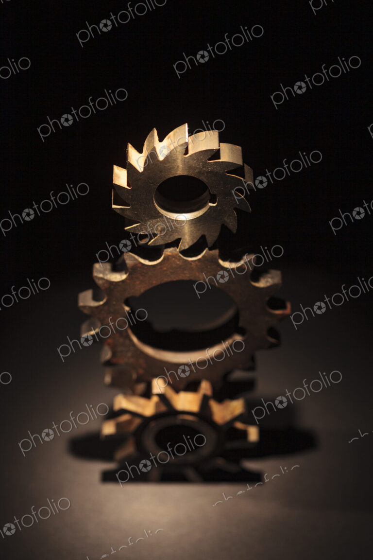 A toy model of a Businessman standing by three stacked cog wheels with different gearing.
