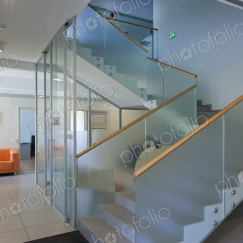 A traditional house with a modern glass extension, two storeys, with glass walls.