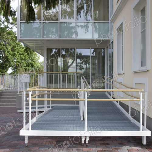 A traditional house with a modern glass extension, two storeys, with glass walls.