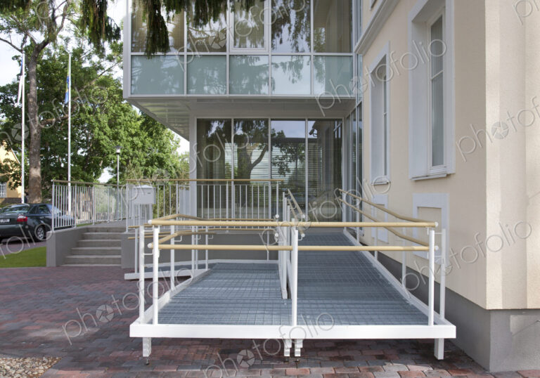 A traditional house with a modern glass extension, two storeys, with glass walls.