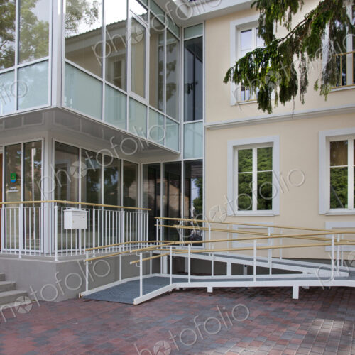 A traditional house with a modern glass extension, two storeys, with glass walls.