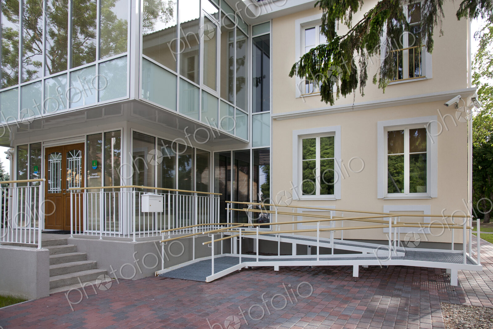 A traditional house with a modern glass extension, two storeys, with glass walls.