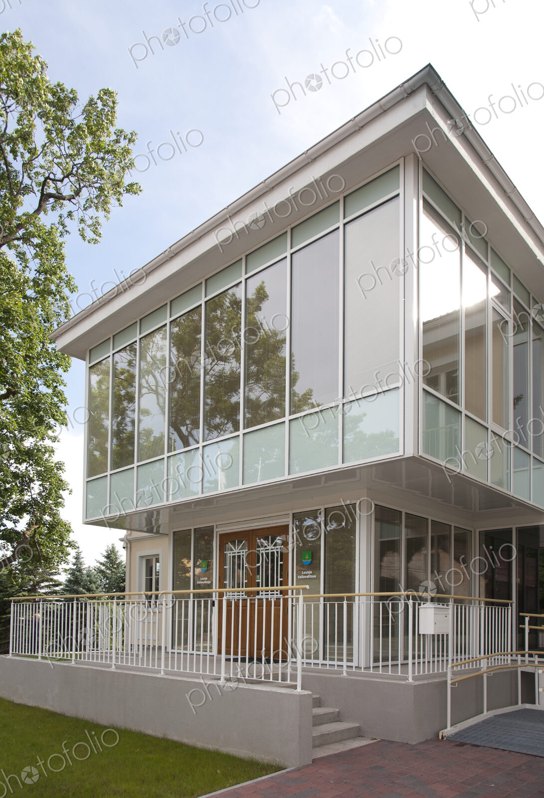 A traditional house with a modern glass extension, two storeys, with glass walls.