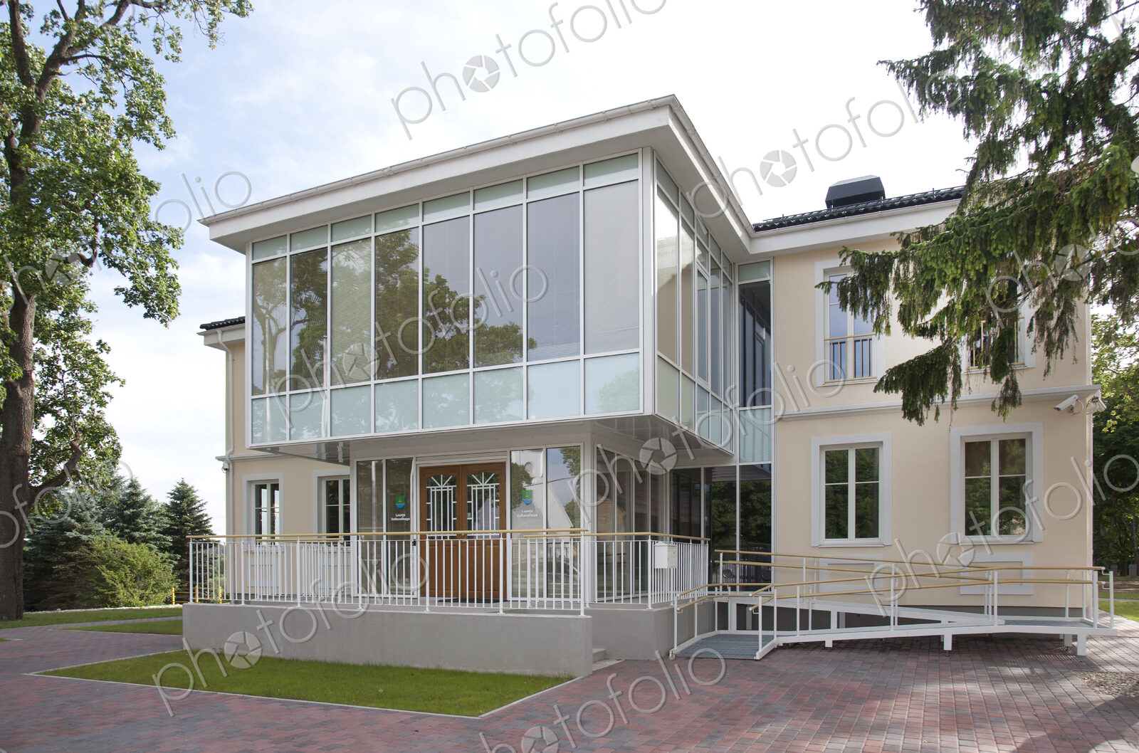 A traditional house with a modern glass extension, two storeys, with glass walls.