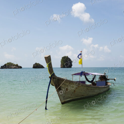 A traditional long tail boat moored in shallow water on Tham Phra Nang beach. A traditional long tail boat moored in shallow water on Tham Phra Nang beach.