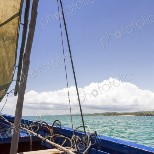 A traditional sailing boat with one sail up, on a calm sea in Antsarinana, north…