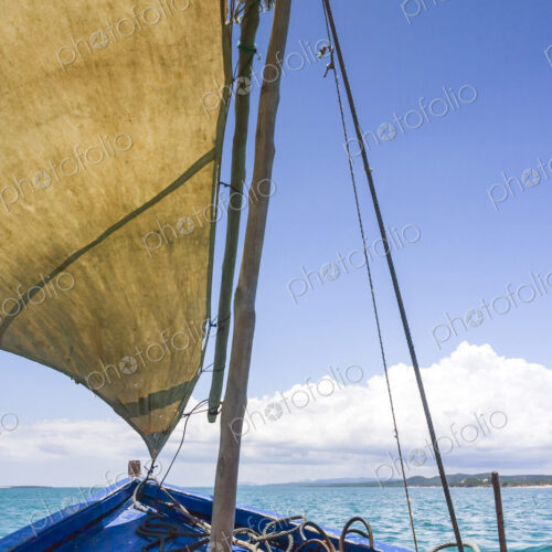 A traditional sailing boat with one sail up, on a calm sea in Antsarinana, north…