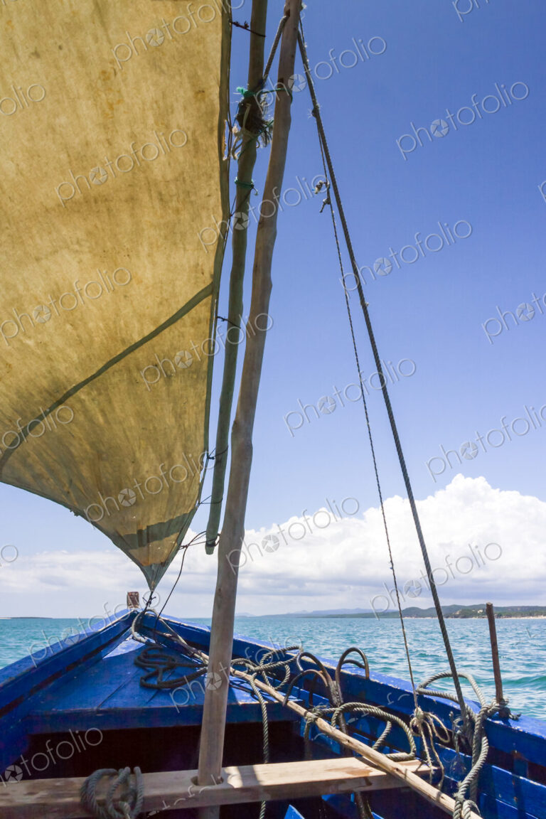 A traditional sailing boat with one sail up, on a calm sea in Antsarinana, north…