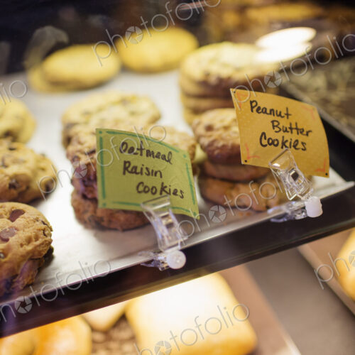 A tray of cookies, biscuits and baked goods on the counter at a coffee shop
