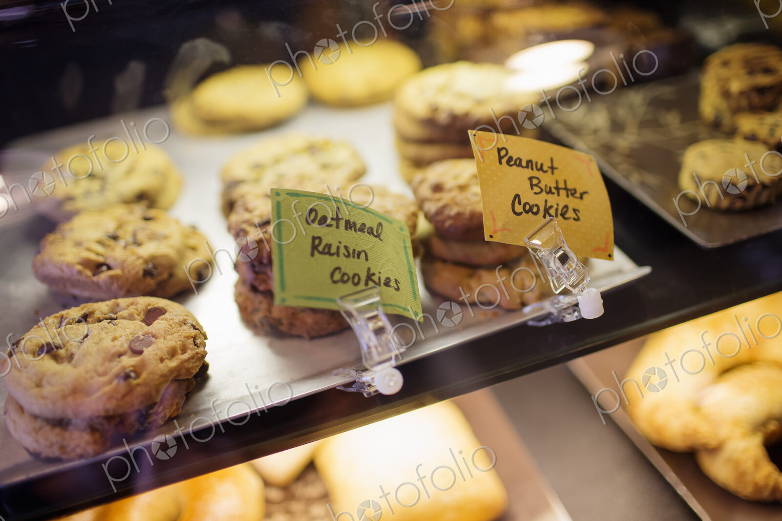 A tray of cookies, biscuits and baked goods on the counter at a coffee shop