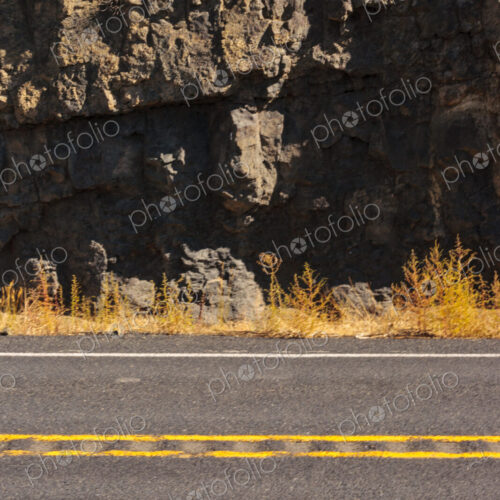 A two lane canyon road and the cliffs of the canyon.