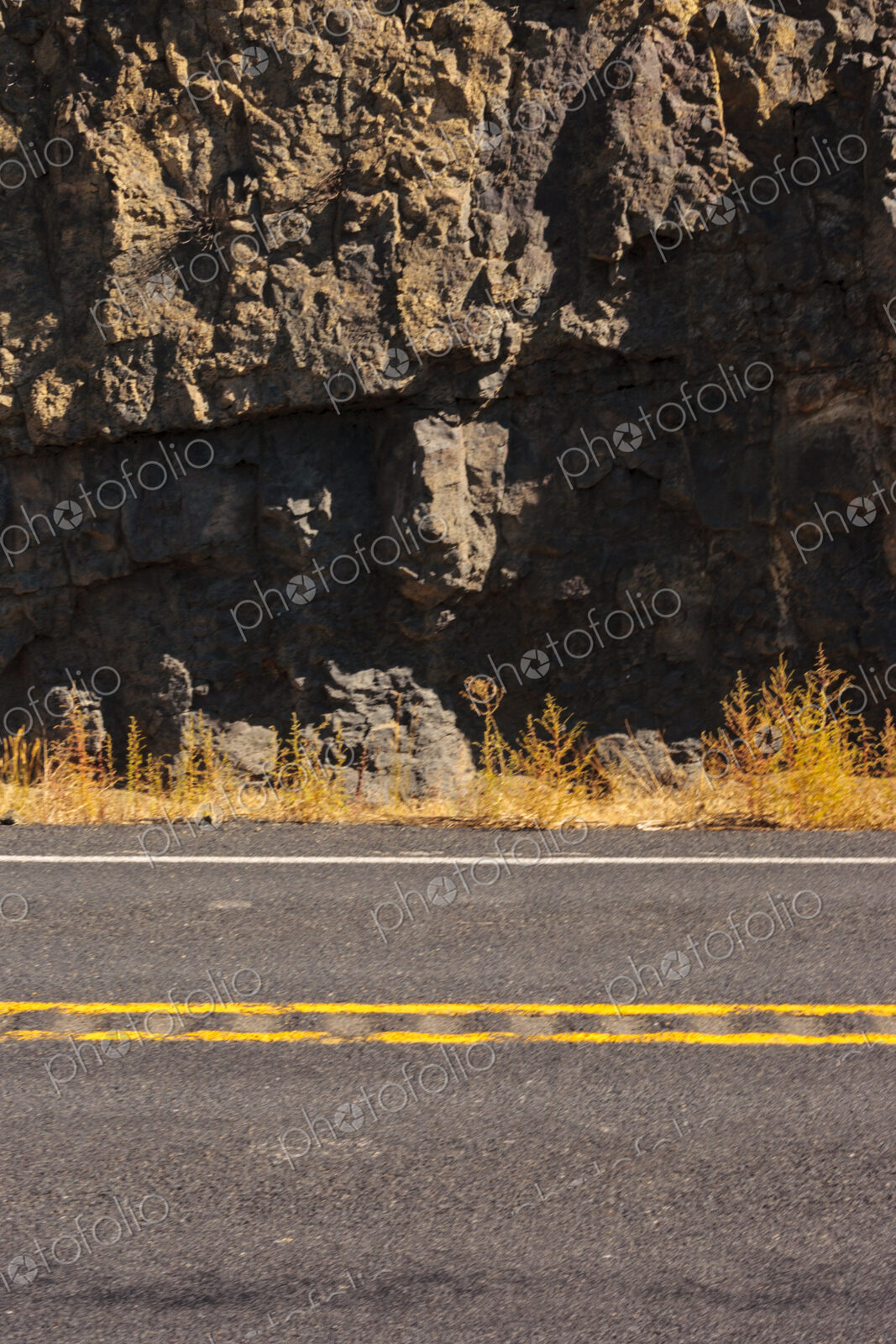 A two lane canyon road and the cliffs of the canyon.
