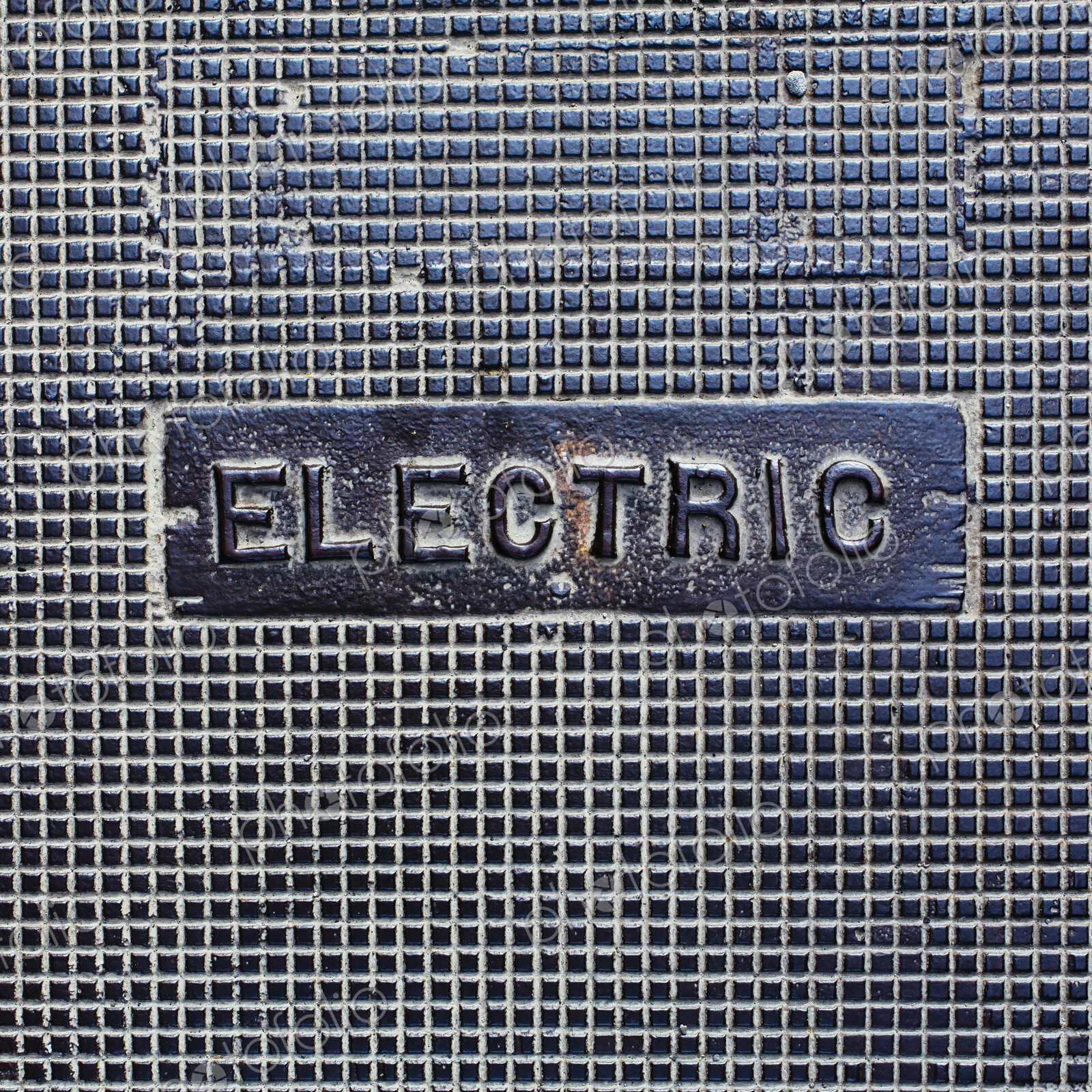 A utility cover made of metal, with the word Electric.
