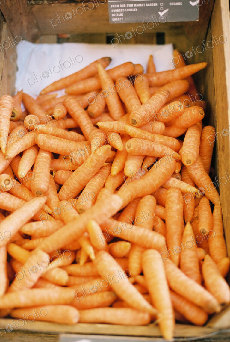 A vegetable box of harvested washed carrots.