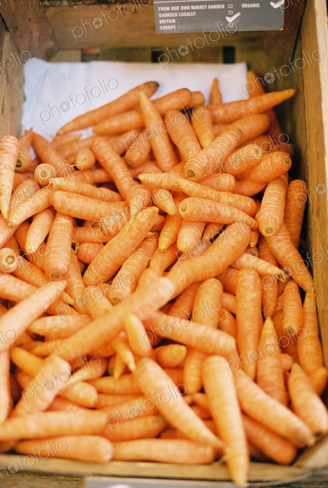 A vegetable box of harvested washed carrots.